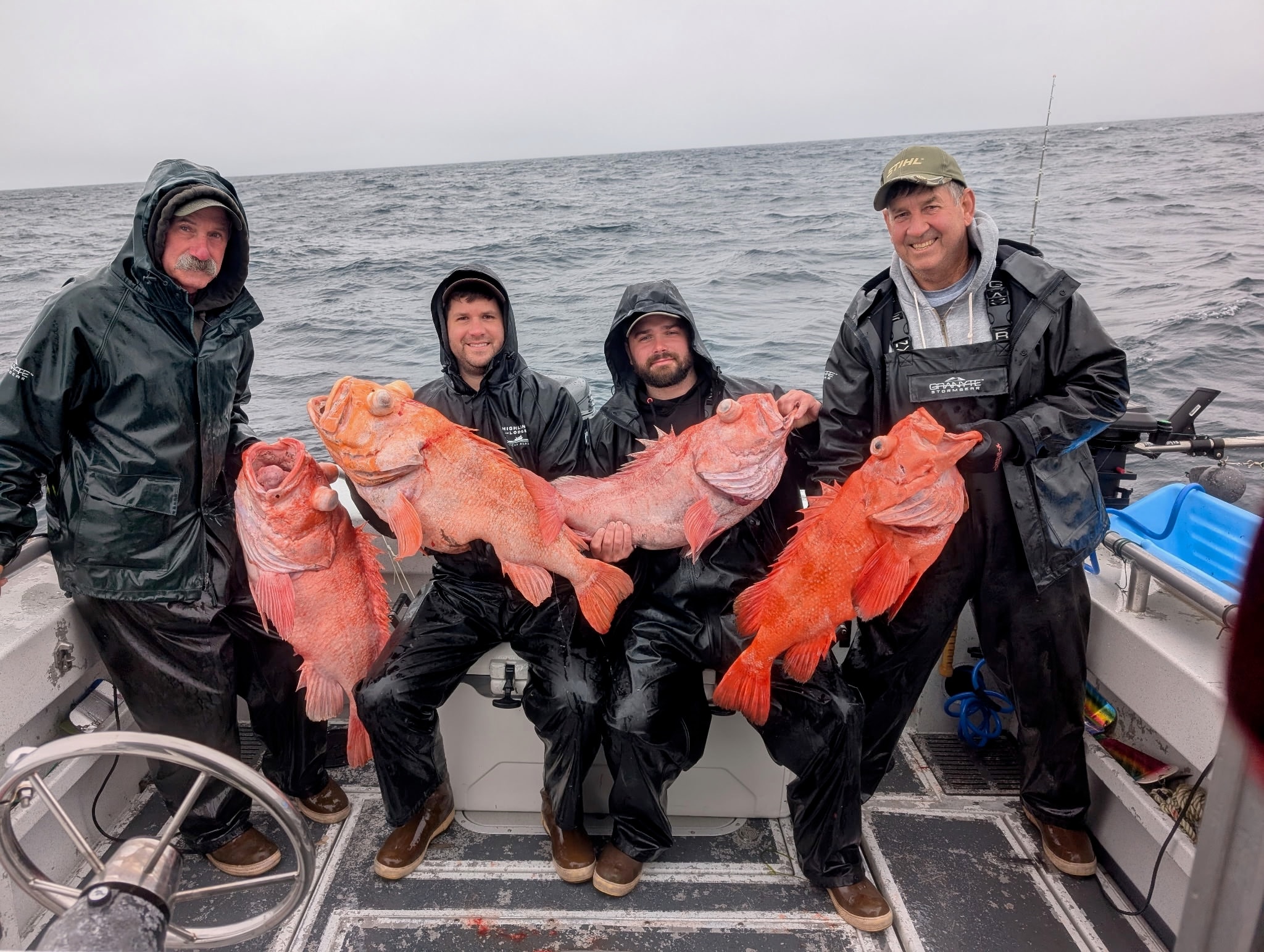 Four anglers holding large shortraker rockfish on a boat in Alaska