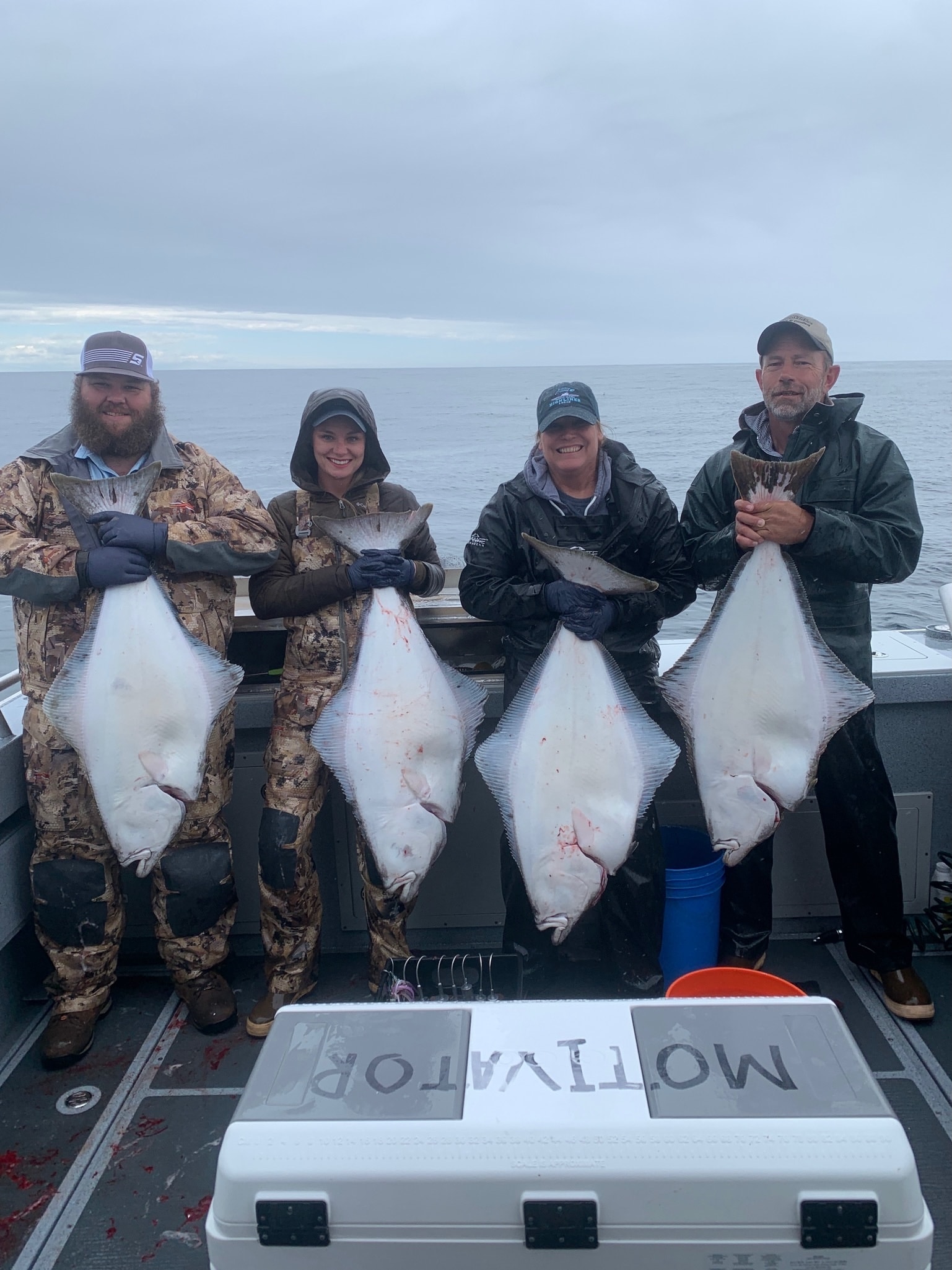 Anglers holding up their catch on a boat in Alaska